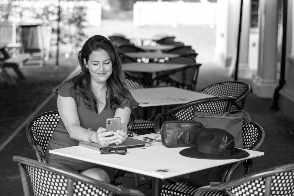 Claire Winter sitting at table with phone