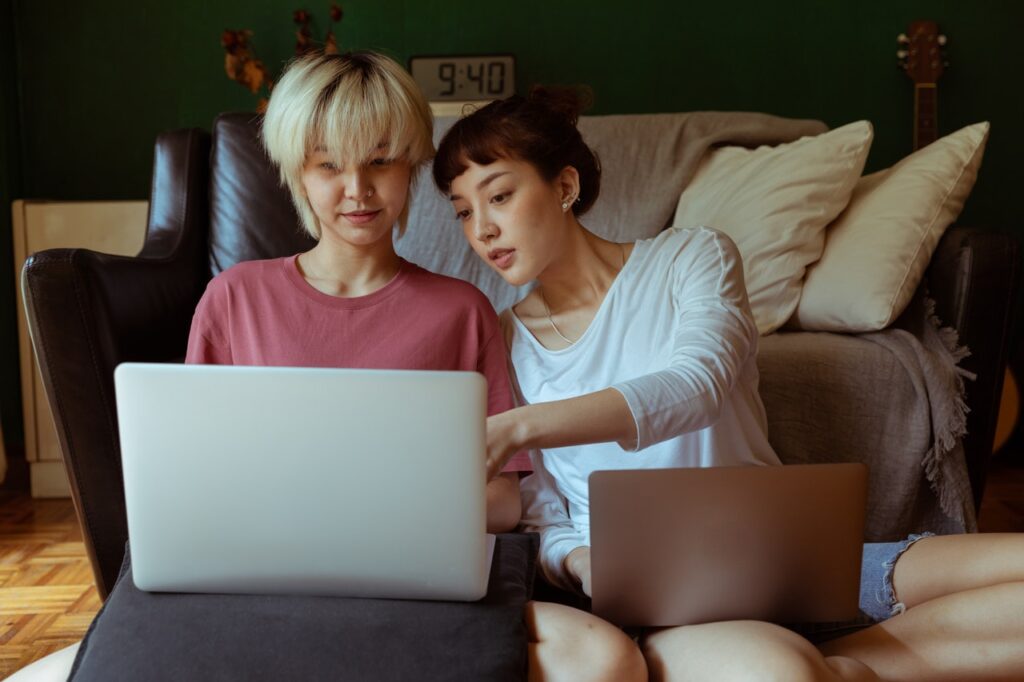 two women pointing at laptop screen