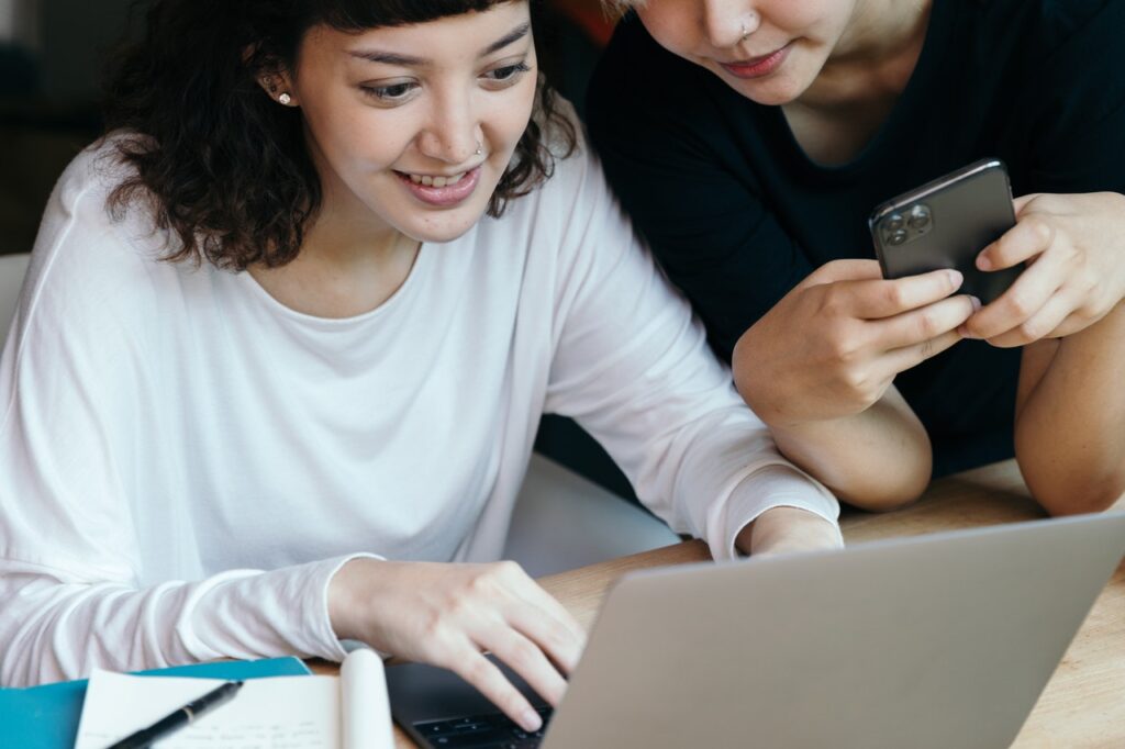 Two woman engaging in front of laptop