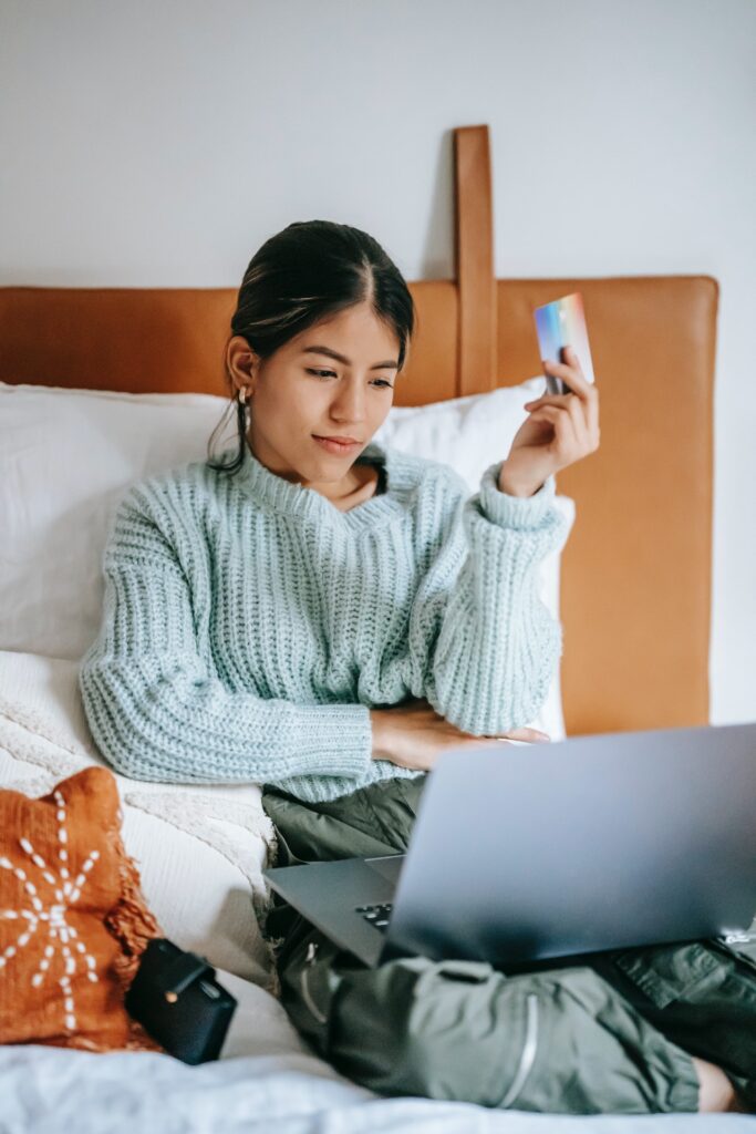 Custome holding credit card in front of laptop