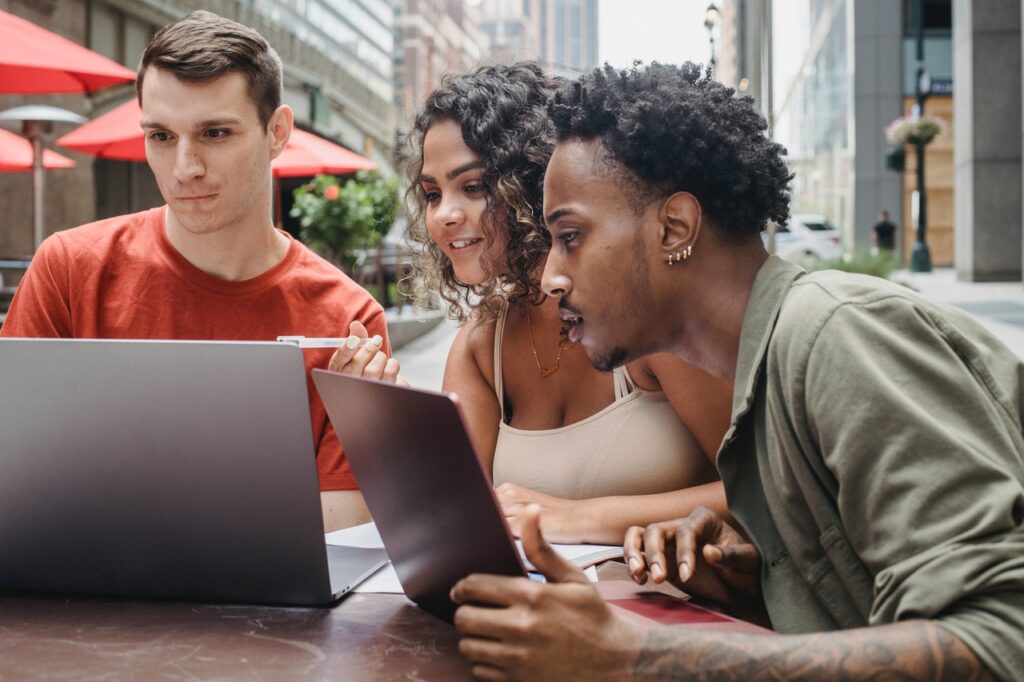 3 people looking at laptop