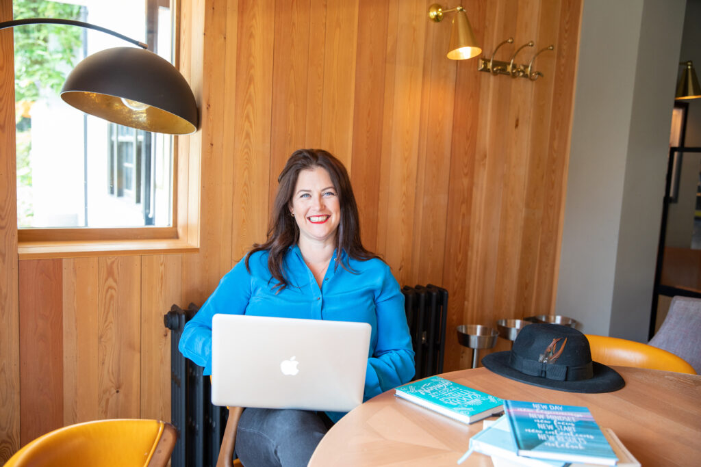 Claire Winter smiling sitting with laptop